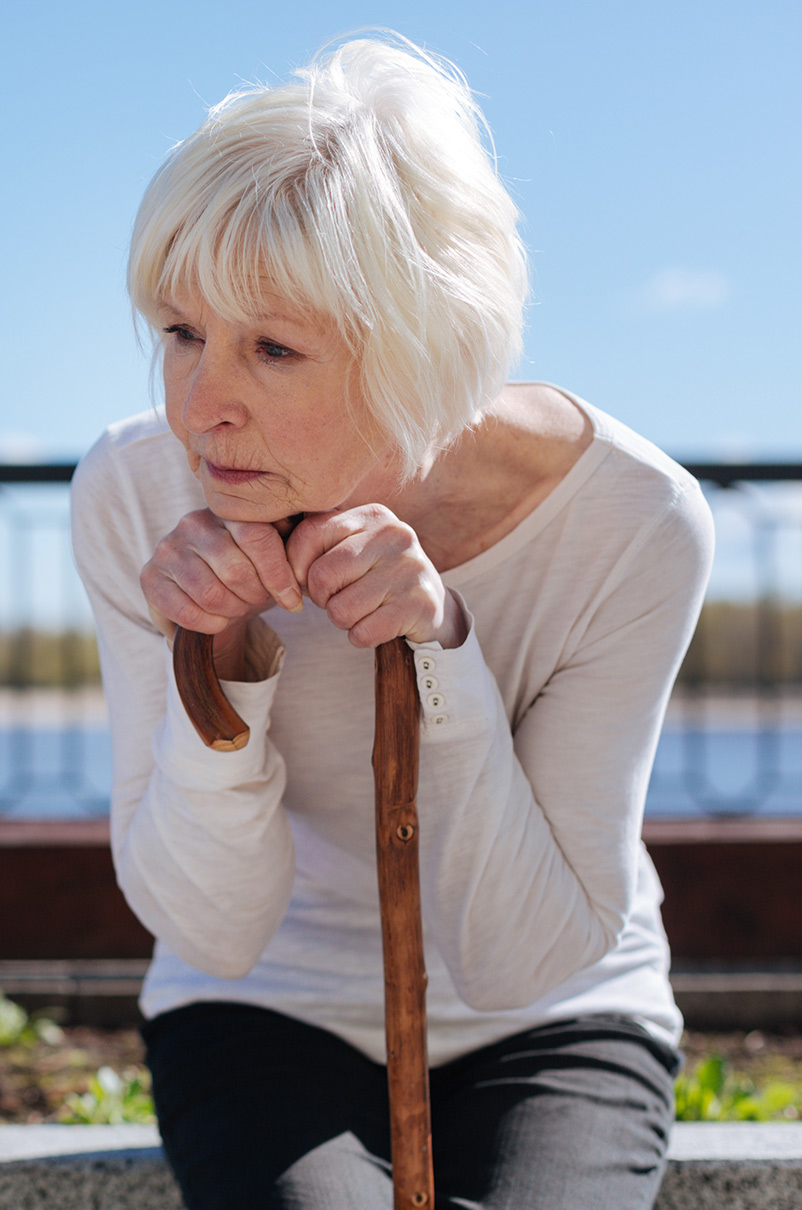 Picture of woman gripped to a cane who is afraid of falling