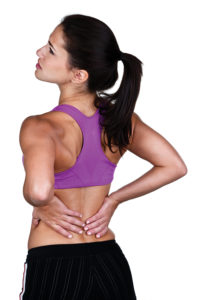 Woman holding her low back - image